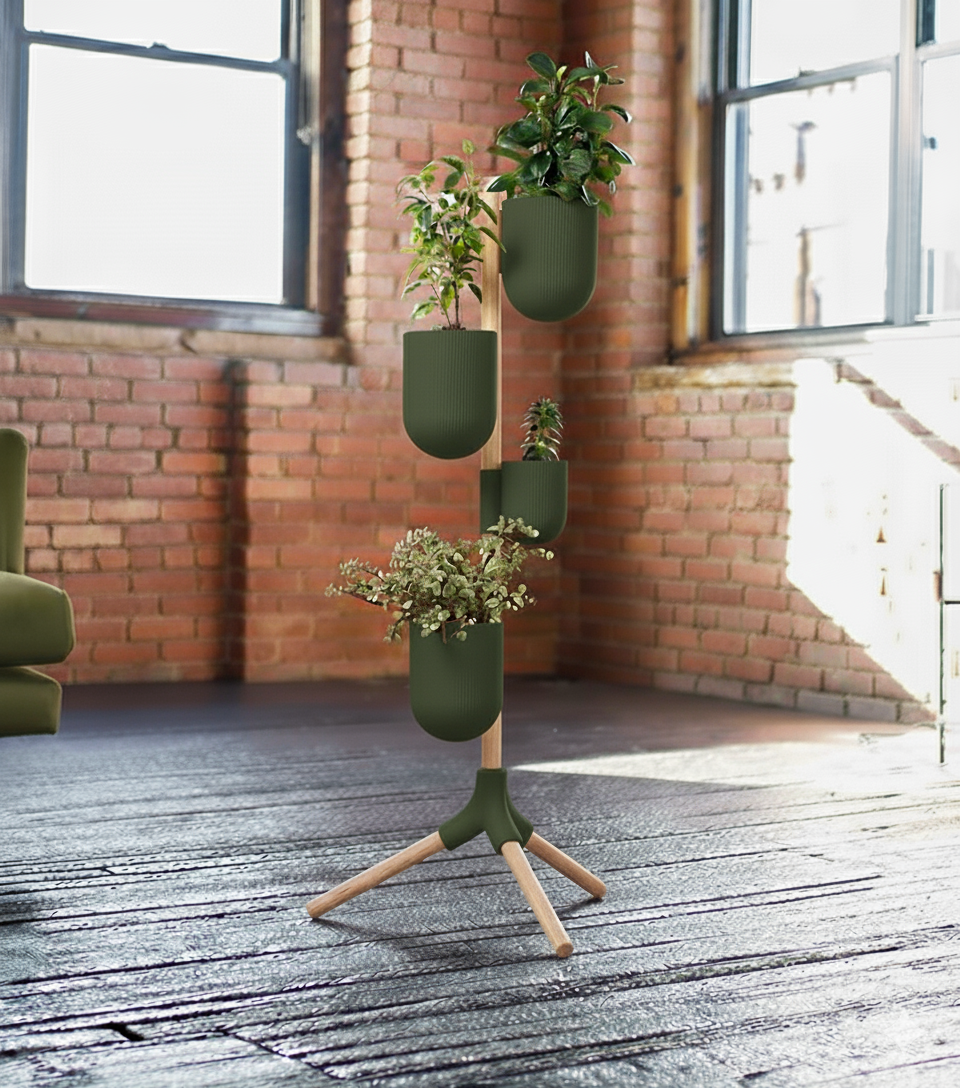 The Evoliv Urban Green – Vertikaler Pflanzenständer für Zuhause mit grünen Töpfen präsentiert verschiedene Pflanzen auf einem Holzfußboden vor großen Fenstern und Backsteinwänden und verleiht dem sonnigen Raum modernen Stil.