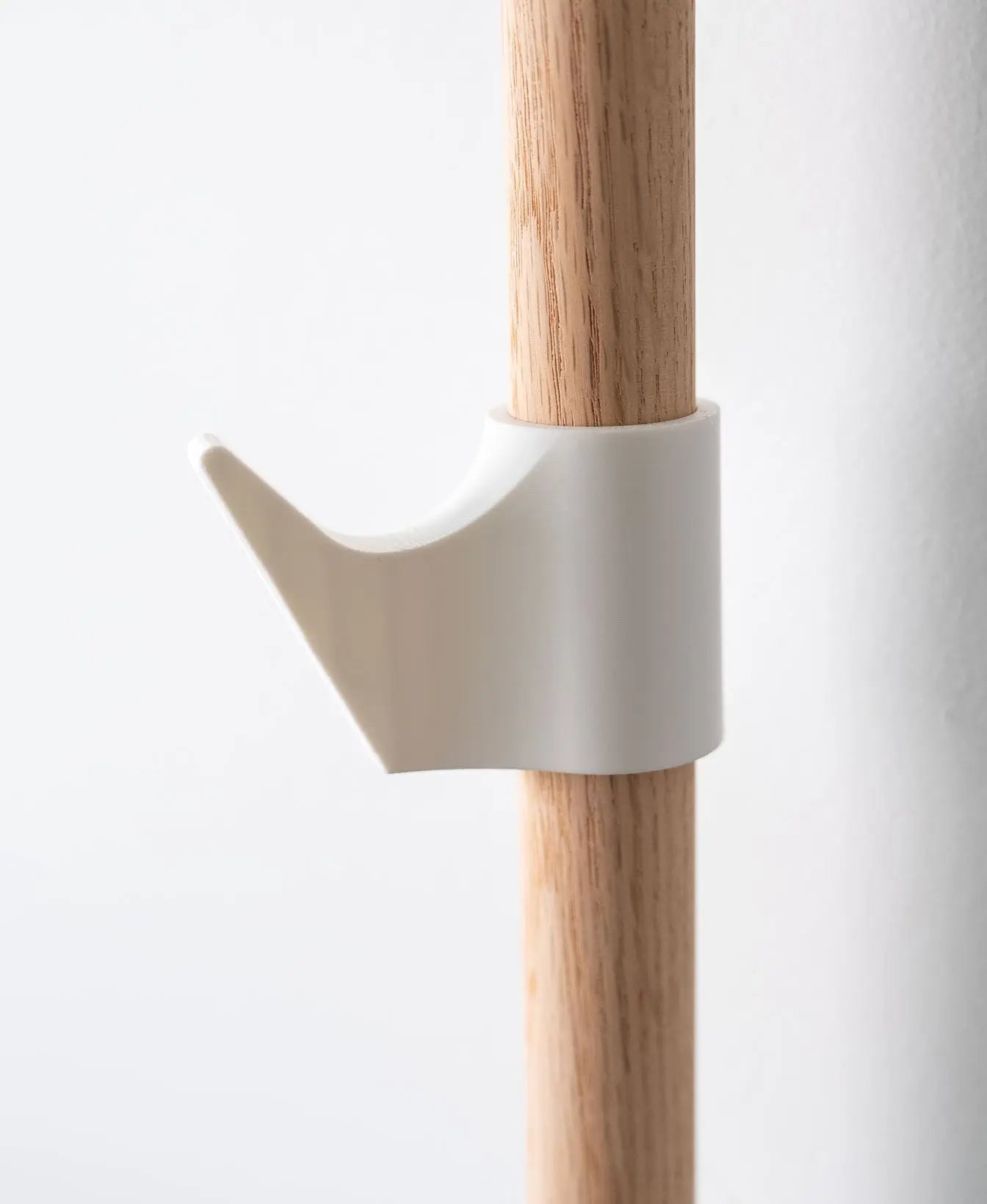 Minimalistischer weisser Haken für das Evoliv Horizontal Rail System an einer Holzschiene zur Aufbewahrung von Accessoires.